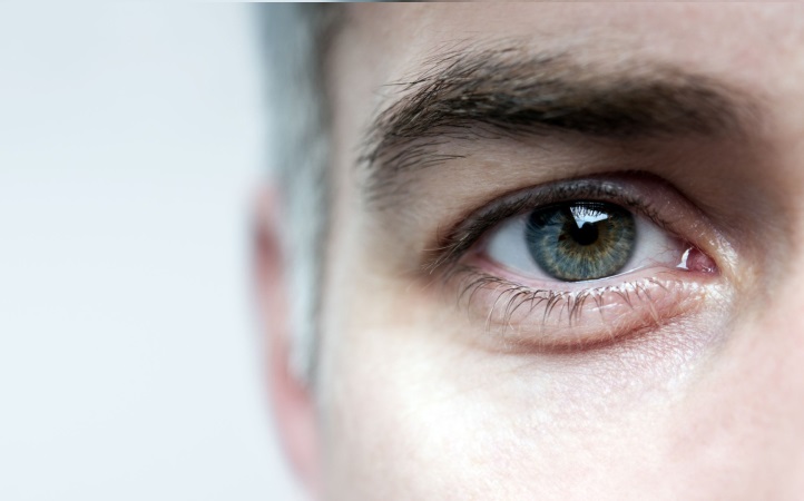 Foto próxima do olho de um homem representando acidente ocular no trabalho